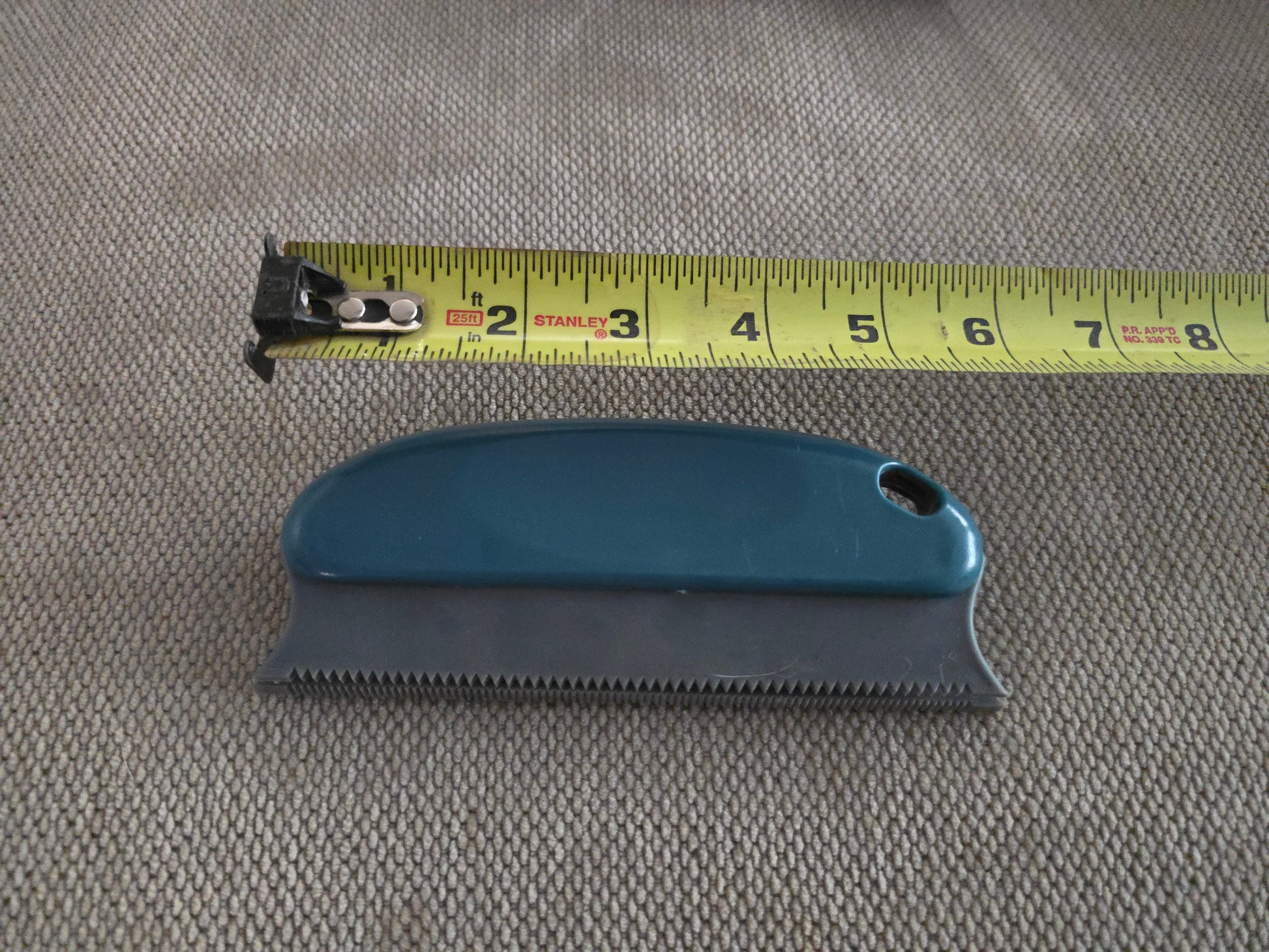 TidyTuft Carpet and Car Pet Hair Detailer beside a tape measure, showing the 6 inch serrated edge